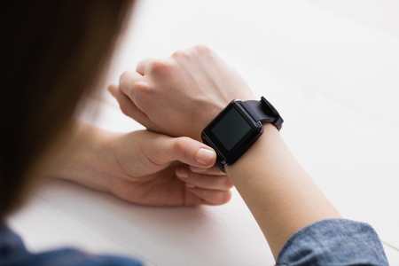 Casual businesswoman using her smart watch at her desk in officeの写真素材