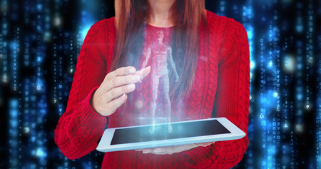 Mid section of a hipster woman using her tablet against lines of blue blurred letters falling