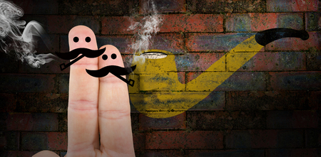 Two fingers with mustache against texture of bricks wallの写真素材
