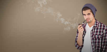 Portrait ofconfident hipster holding smoking pipe against grey background with vignetteの写真素材