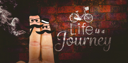 Two fingers with mustache against texture of bricks wallの写真素材