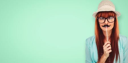 Happy smiling hipster with a mustache against green backgroundの写真素材