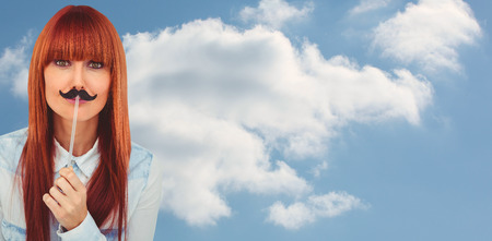 Portrait of a hipster woman with a mustache against cloudy sky