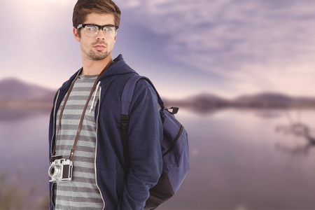 Confident man wearing eye glasses against lake