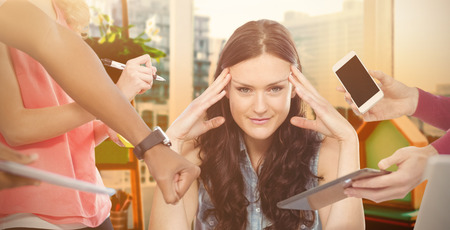 Woman with head in hands against view of a business desk