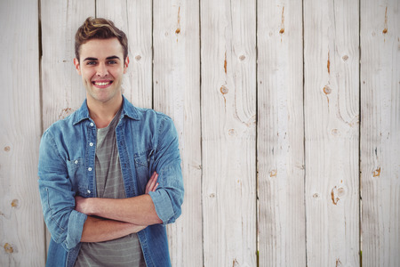 Smiling creative businessman by his desk against wooden backgroundの写真素材