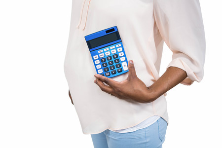 Pregnant woman holding calculator on white backgroundの写真素材
