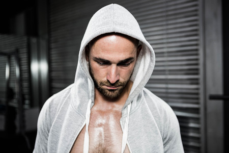 Shirtless man wearing jumper looking down at the crossfit gymの写真素材