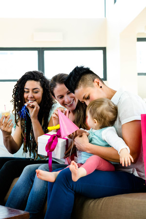 Three women sitting on a couch celebrating a babies first birthday