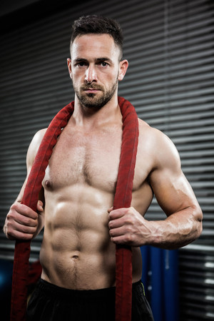 Shirtless man with battle rope around neck at the crossfit gymの写真素材