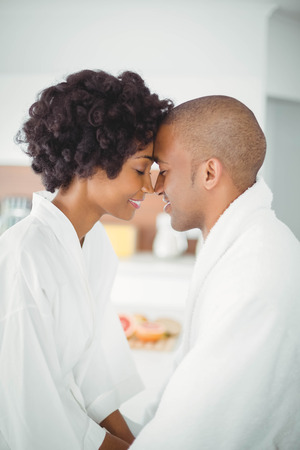 Happy couple hugging in the kitchen at homeの写真素材