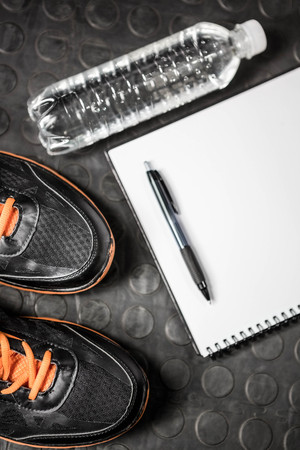Notepad, shoes and bottle at the crossfit gymの写真素材