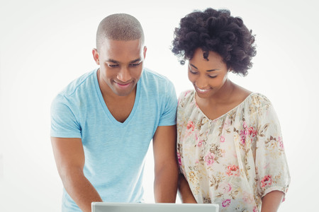 Smiling couple using laptop together at homeの写真素材