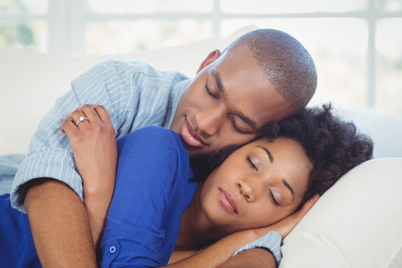 Peaceful couple sleeping on the sofaの写真素材