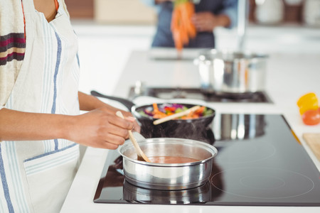 Happy couple preparing meal in the kitchenの写真素材