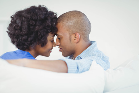 Portrait of smiling couple on the sofa nose to noseの写真素材