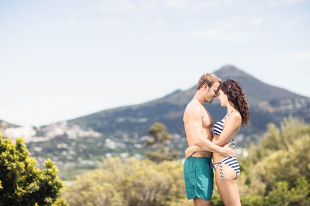 Young couple cuddling each other near pool on a sunny dayの写真素材