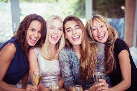 Portrait of beautiful women smiling and having drinks at the partyの写真素材