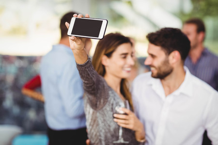Young friends taking selfie at the partyの写真素材