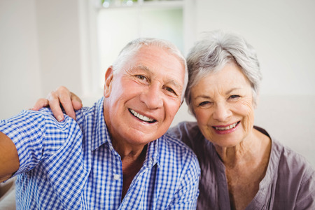 Portrait of senior couple smiling in living room