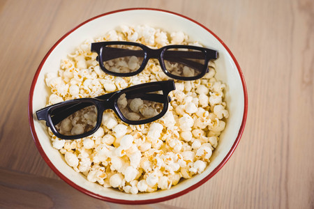 Close-up of 3D glasses in bowl of popcorn on tableの写真素材