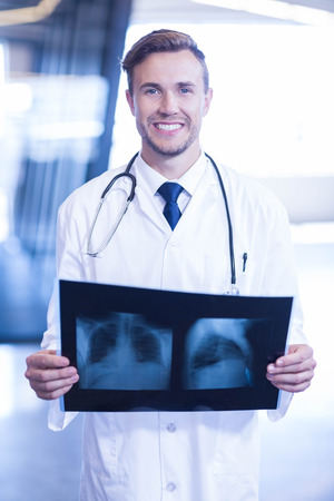 Portrait of doctor holding an x-ray in hospitalの写真素材