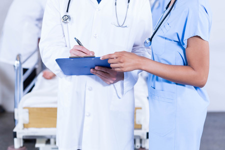 Doctors writing on clipboard in hospitalの写真素材