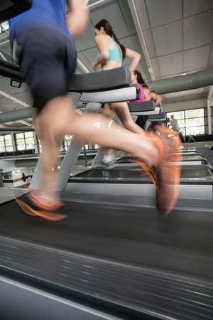 Women and men running on a treadmill at the gym