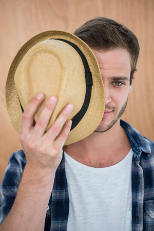Handsome hipster wearing hat on wooden backgroundの写真素材