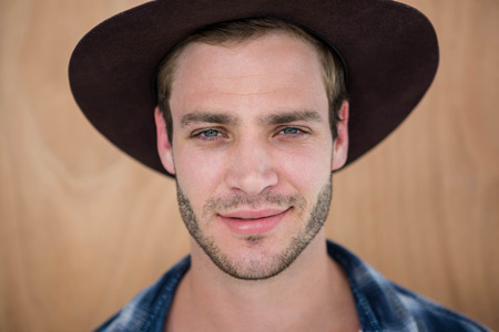 Handsome hipster wearing hat on wooden background
