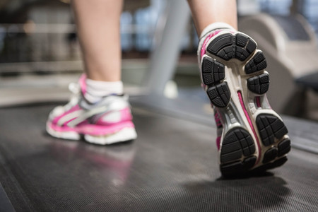Feet of a woman on a treadmill in a gymの写真素材