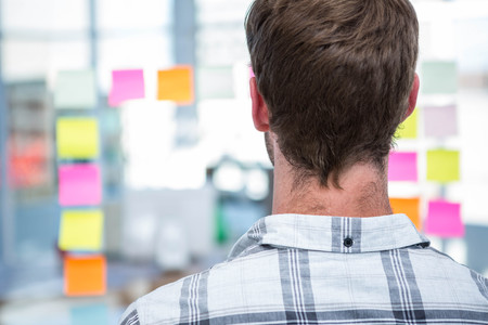 Hipster man in front of post-it in officeの写真素材