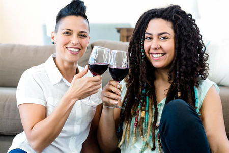 Portrait of lesbian couple smiling and toasting wine glassesの写真素材