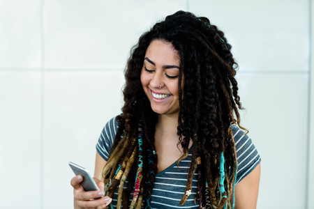 Woman smiling while typing a text messageの写真素材