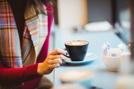 Woman holding a cup of coffee in a cafe