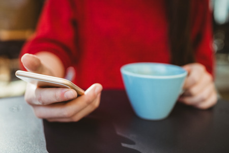 Woman using her smartphone in cafe