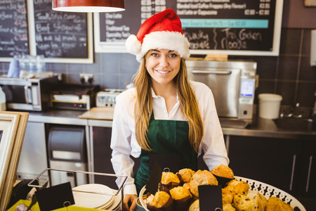 Cute waitress standing behind the counter in a coffee shopの写真素材