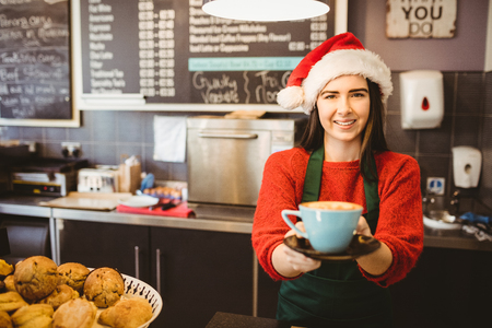 Cute waitress giving a coffee to customer in a coffee shopの写真素材