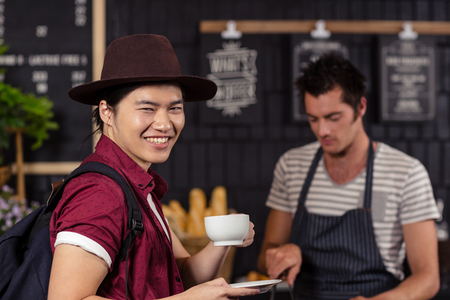 Happy customer drinking coffee at the coffee shopの写真素材