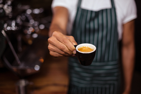 Barista offering an espresso in the coffee shopの写真素材