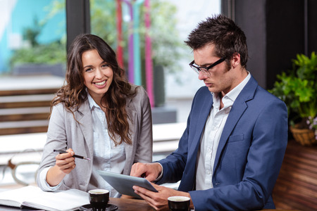People using tablet and notebook in a cafeの写真素材