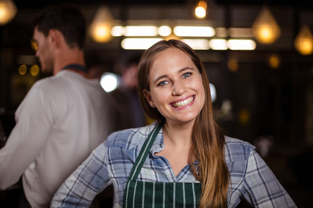 Smiling barista looking at the camera in the barの写真素材