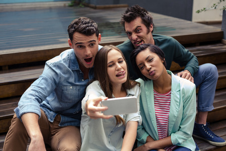 Happy friends taking selfie outside the barの写真素材