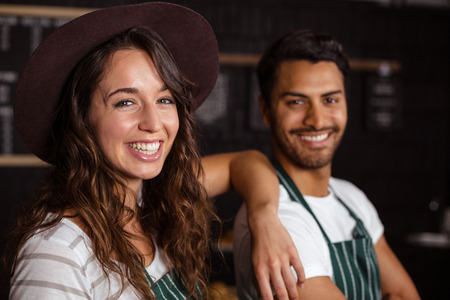 Smiling baristas looking at the camera in the barの写真素材