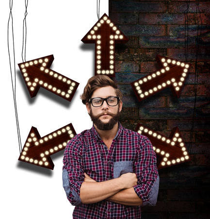 Confident hipster wearing eye glasses with arms crossed against brick wallの写真素材