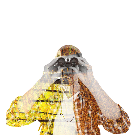 Hipster looking through binoculars against trees in the autumnal forestの写真素材