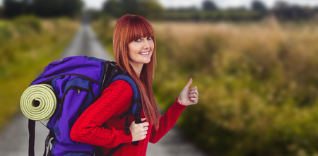 Smiling hipster woman with a travel bag against picture of an empty street