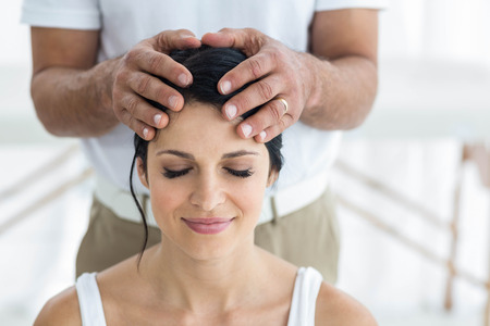 Pregnant woman receiving a head massage from masseur at homeの写真素材
