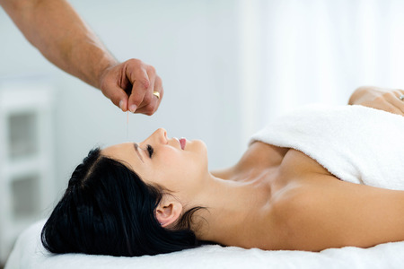 Pregnant woman receiving a spa treatment from masseur at home
