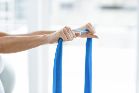 Pregnant woman performing stretching exercise at home